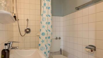 A bathroom with a white sink, a toilet, and a shower with a blue shower curtain.