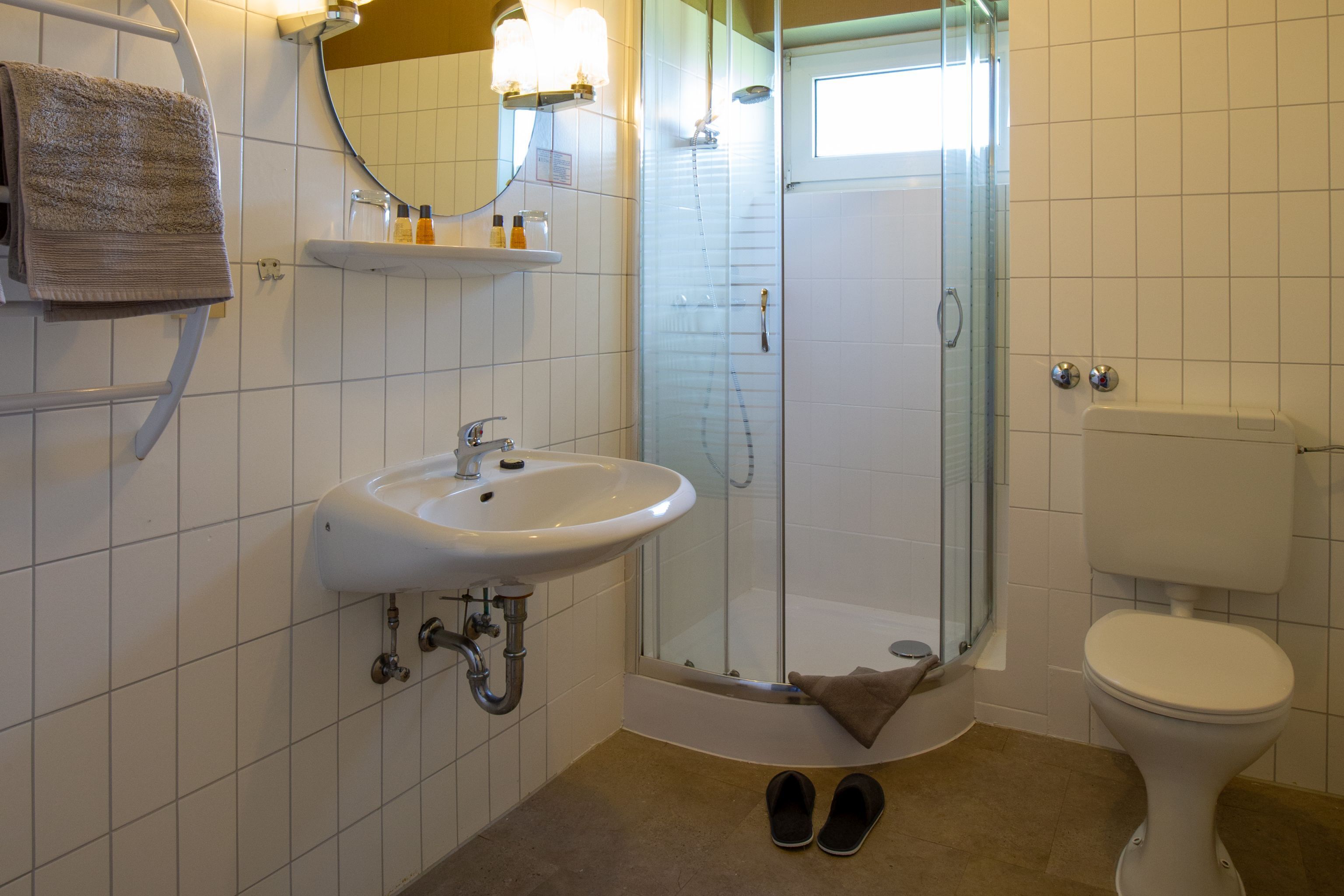 Ein Badezimmer mit Waschbecken, Toilette und einer Duschkabine.