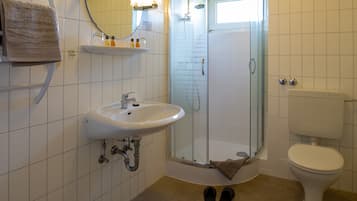 Ein Badezimmer mit Waschbecken, Toilette und einer Duschkabine.