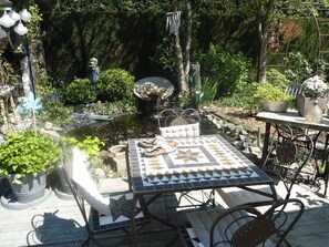 A garden patio with a tiled table, metal chairs, and a small pond. - Country-Style Cottage (Beernem)
