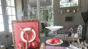 A dining area with a checkered tablecloth, a wicker basket with food items, and a decorative wall with hanging lights.