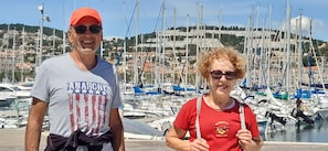Twee personen staan voor een jachthaven met diverse boten aanmerkt.