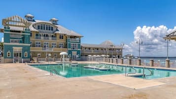 Et stort resort med swimmingpool, flere balkoner og havudsigt.