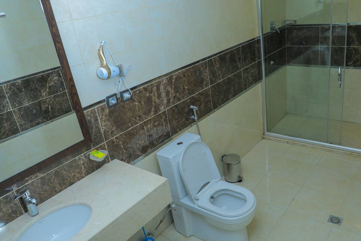 A bathroom with a toilet, sink, and shower area.