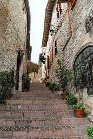 A narrow stone staircase leading up to a building with a rustic, historical appearance. - Casa Kennedy Assisi Views, 2 Baths & Easy Parking (Castelnuovo)
