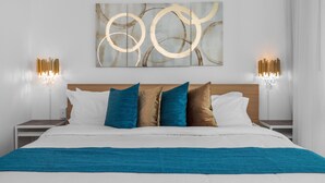 A neatly made bed with a blue blanket, a headboard, and a wall art piece above it. - JR ONE BR ESJ TOWERS! HIGH FLOOR,VIEW LOCATION! (Carolina)