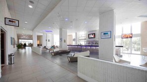 A spacious lobby with a reception desk, seating areas, and a bar. - JR ONE BR ESJ TOWERS! HIGH FLOOR,VIEW LOCATION! (Carolina)