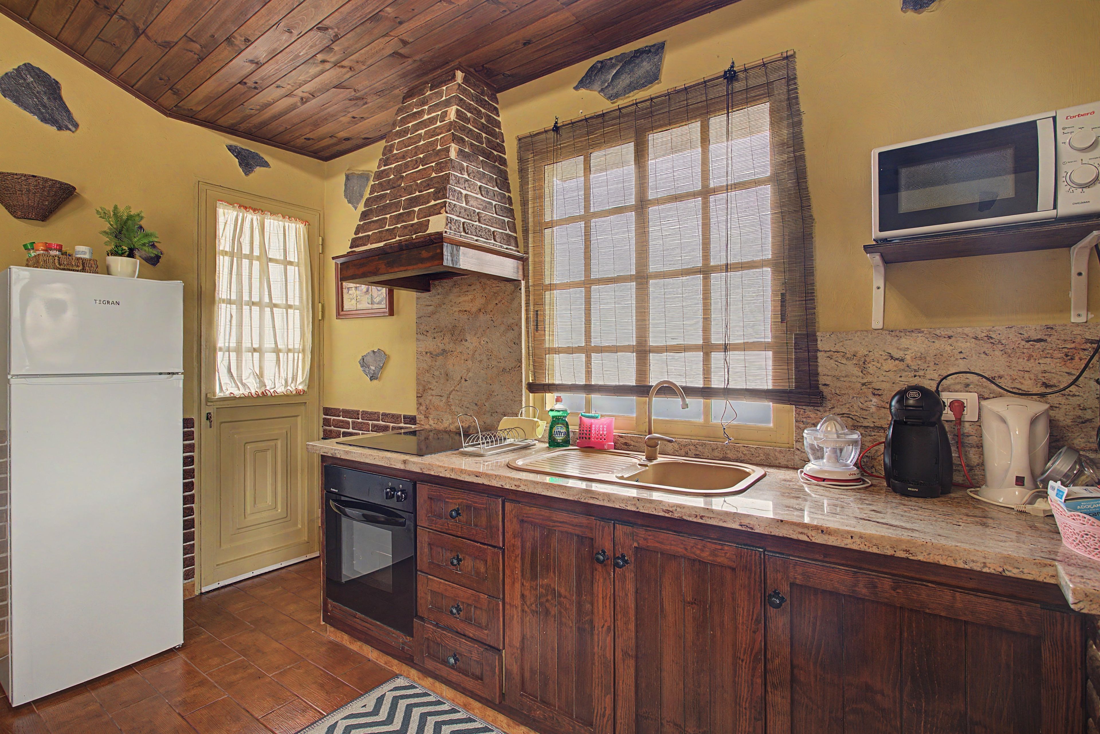 Una cocina equipada con refrigerador, estufa, pileta y microondas.