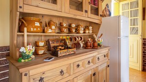 A kitchen with wooden cabinets, a refrigerator, and various kitchenware. - Vacation Home Casa La Chocita with Sea View, Mountain View (Los Realejos)