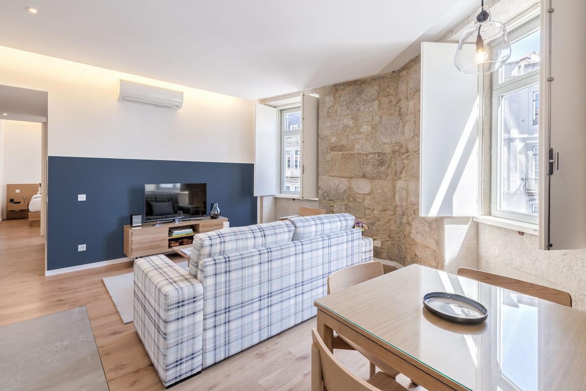 Un salon moderne avec un canapé, une table à manger et un téléviseur.