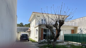 A two-story house with a car parked in the driveway. - le lac Devant sa Porte- Base de Bombannes Proche , Ocean à 5 Minutes (Carcans)