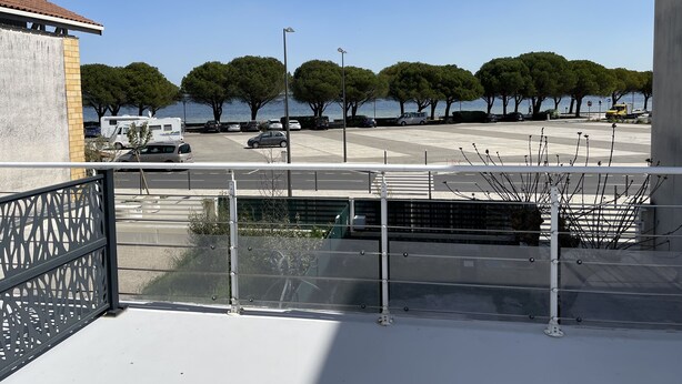 A parking area with trees and a view of the sea. - le lac Devant sa Porte- Base de Bombannes Proche , Ocean à 5 Minutes (Carcans)
