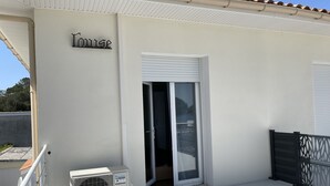 A building with a sign reading "House," a sliding glass door, and an air conditioning unit on the balcony. - le lac Devant sa Porte- Base de Bombannes Proche , Ocean à 5 Minutes (Carcans)
