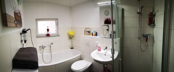 Un baño con bañera, inodoro, lavabo y ducha.