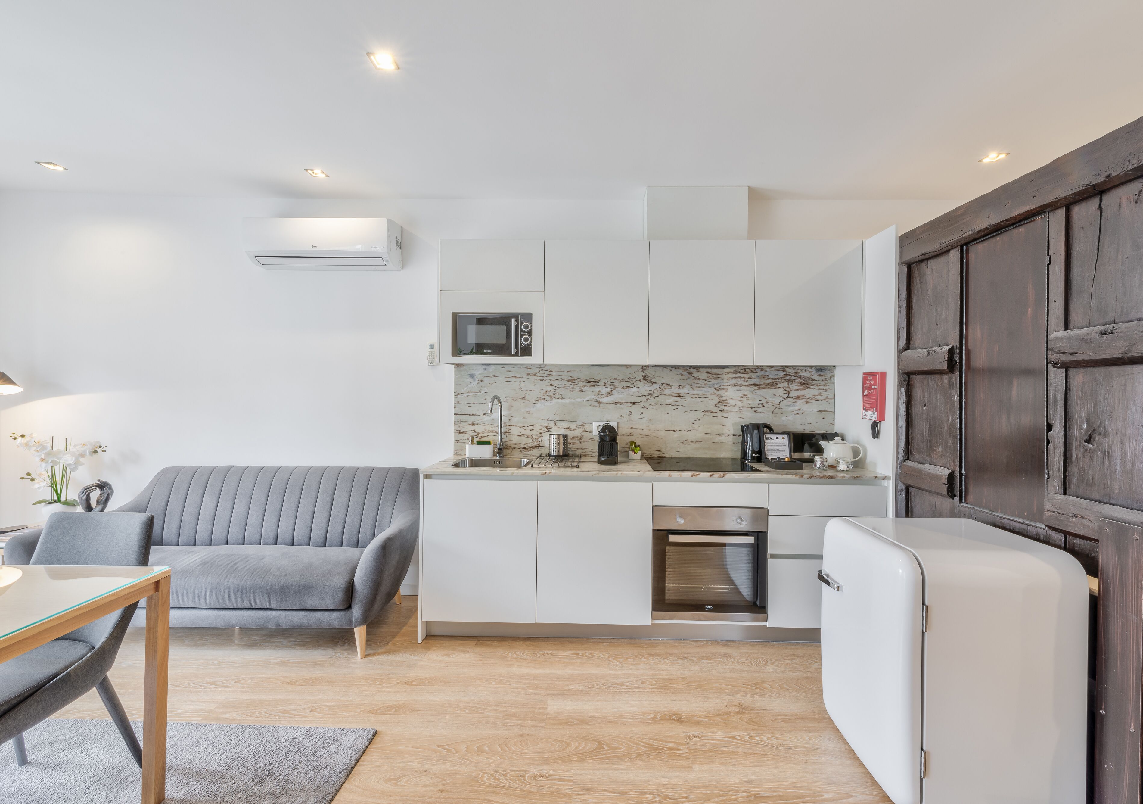 A compact kitchen with a microwave, coffee maker, and oven.