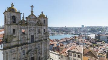 A historic church with a bell tower and a view of the cityscape below.
