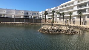 Un edificio moderno con numerosi balconi e un'isola rocciosa nell'acqua.