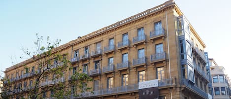 A multi-story building with balconies and a sign for Nuevo Hotel.
