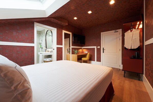 A bedroom with a bed, a desk, a chair, a TV, and a wardrobe. - Intelier Villa Katalina Hotel by Intelier Hotels & Suites (San Sebastián)
