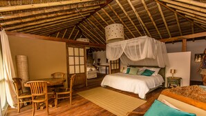 A rustic room with a bed, a desk, and a chair. - Villa del Sol Mancora (Máncora)