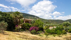 A house surrounded by lush greenery and hills. - Villa Calu' - Wonderful villa in Sardinia with swimming pool and sea view (Tertenia)