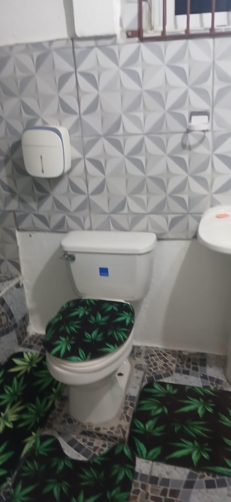 Une salle de bain équipée de toilettes, d’un sèche-mains et d’un lavabo.