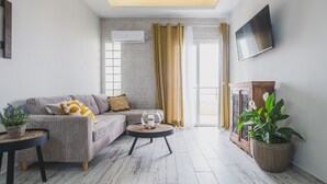 Een moderne woonkamer met een bank, salontafel en potplanten.