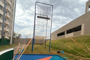 An outdoor gym area with a climbing wall, a basketball court, and a swimming pool. - Enjoy Solar das Águas Park Resort (Olímpia)