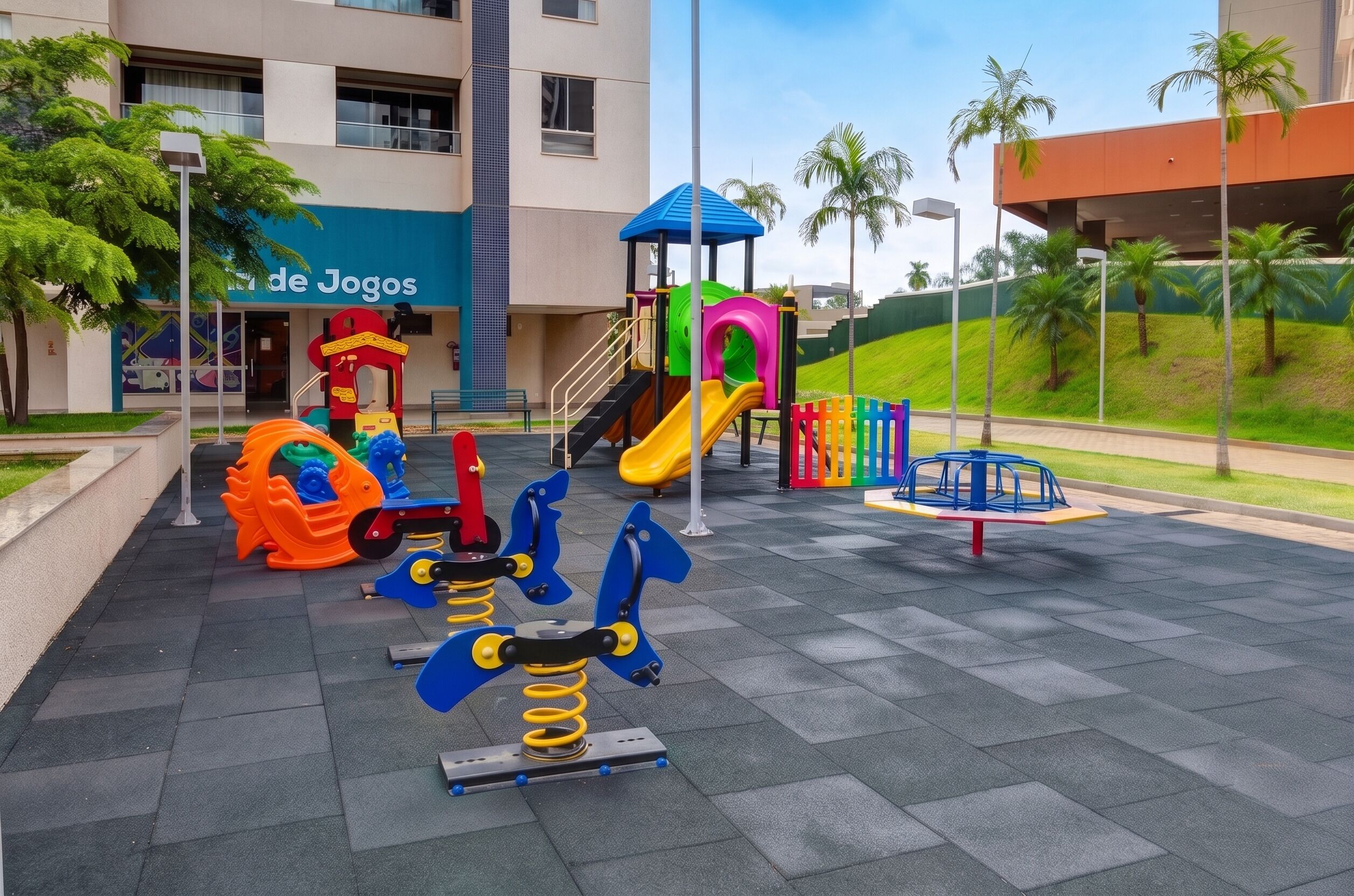 Un parque infantil con diversas estructuras de juego, incluyendo toboganes y columpios, frente a un edificio con un letrero que dice 'de Juegos'.