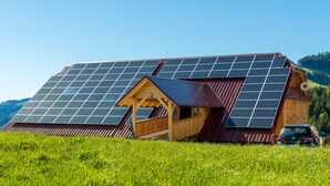 A wooden cabin with a sloped roof and solar panels.