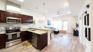 Una cocina moderna con armarios de madera oscura, electrodomésticos de acero inoxidable y una isla grande.