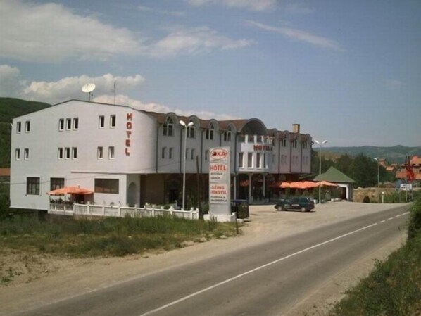 A two-story motel with a white facade and a sign indicating it is a hotel.