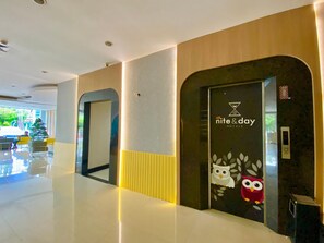 A hotel lobby with a modern design, featuring a reception desk, a Christmas tree, and a wall with an owl decoration. - All Nite and Day Makassar (Makassar)
