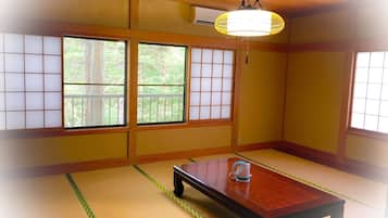 A traditional Japanese room with tatami flooring, a low wooden table, and shoji screens.