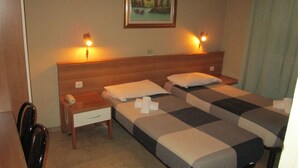 A hotel room with two single beds, a nightstand with a phone, and a painting on the wall. - Ca Grande (Milan)