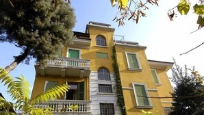 A multi-story yellow building with a balcony on the second floor. - Ca Grande (Milan)