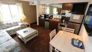 A compact living space with a sofa, coffee table, dining table, and kitchenette. - Thunderbird Resort Club (Sparks)