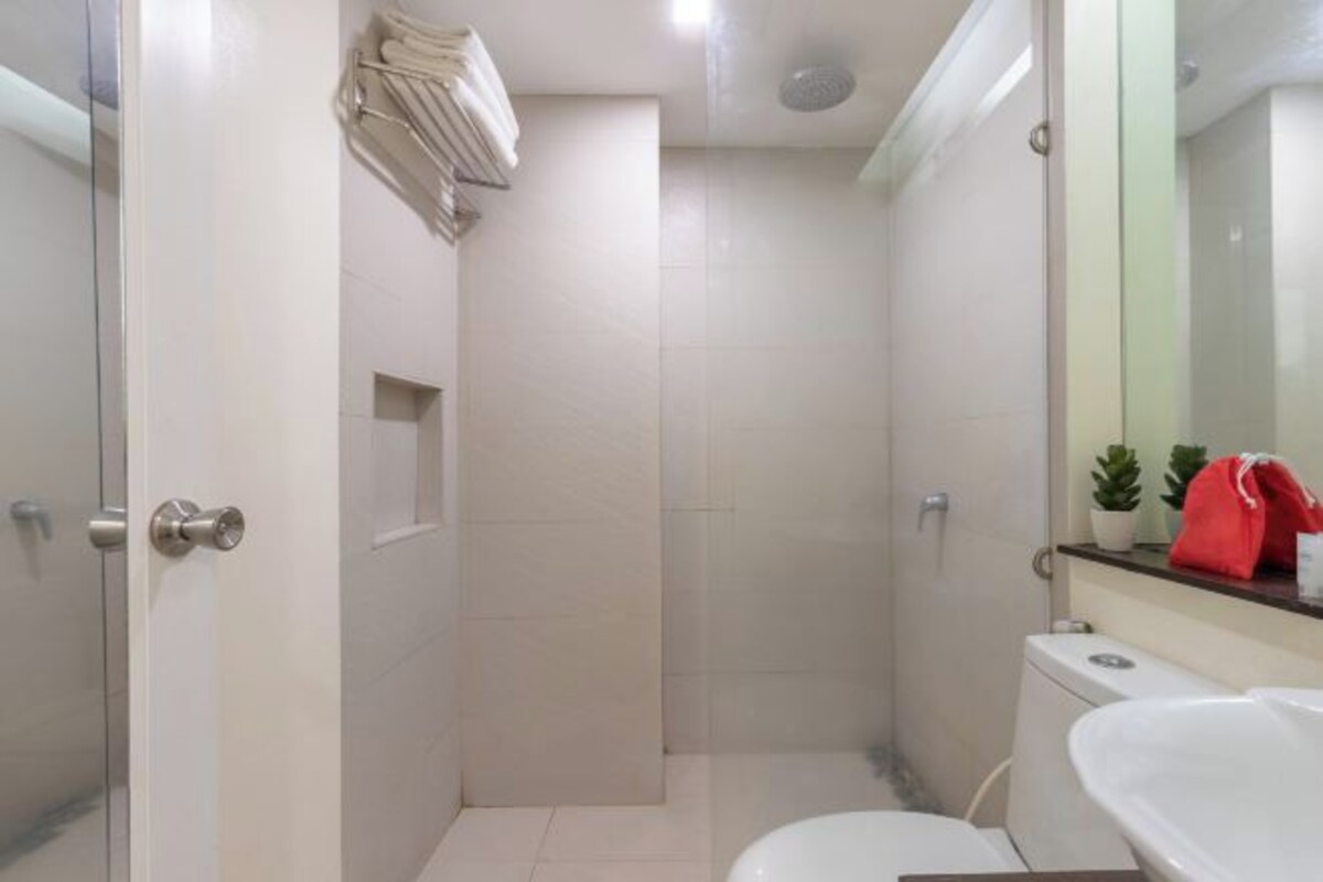 A bathroom with a toilet, sink, and shower area.
