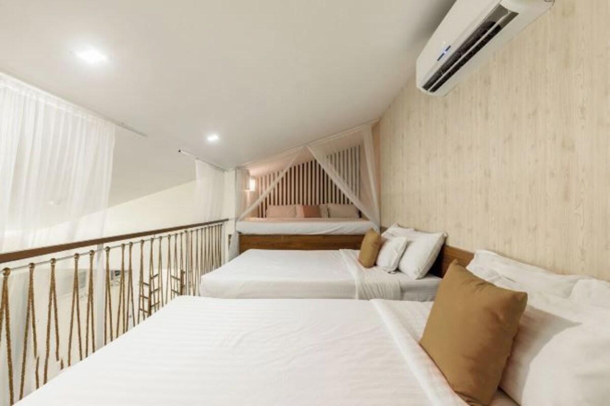 A hotel room with two beds, a balcony, and an air conditioning unit.