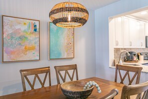 Un comedor con una mesa de madera, cuatro sillas y un cuenco decorativo.