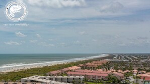 Une station balnéaire comprenant plusieurs bâtiments, une plage et un court de tennis.