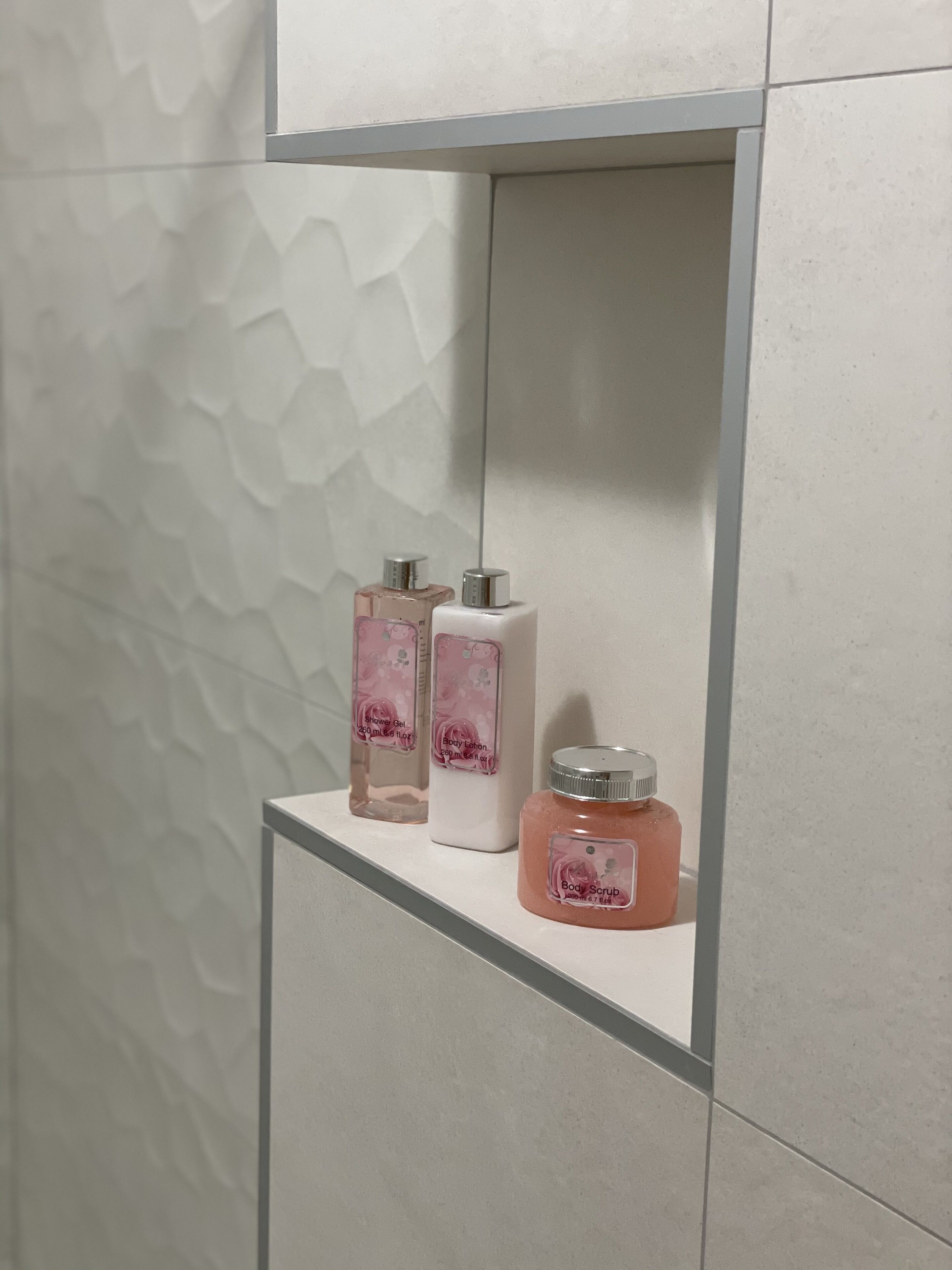 A bathroom shelf with three toiletry bottles.