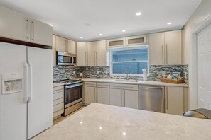 A modern kitchen with a refrigerator, microwave, stove, and dishwasher.