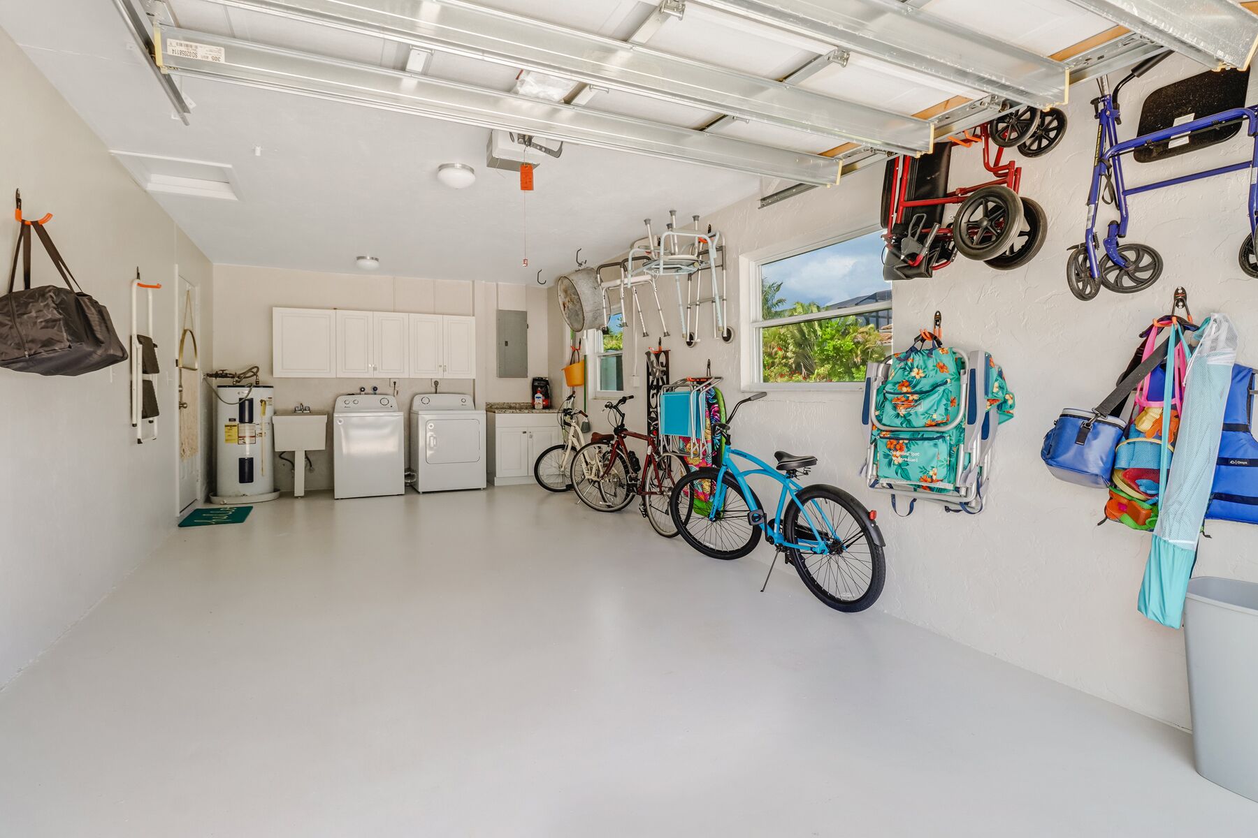 A spacious garage with a washing machine, dryers, and a bicycle.