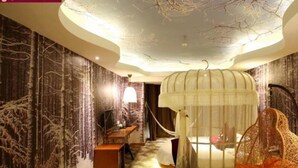 A room with a unique ceiling design, a hanging chair, and a bed with a canopy. - Grand Nest Hotel (Zhuhai)