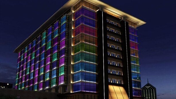 A multi-story hotel with a modern facade, featuring a series of illuminated windows and a prominent entrance with a ramp. - Grand Nest Hotel (Zhuhai)