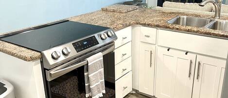 A kitchen with a built-in stove, oven, and a sink.