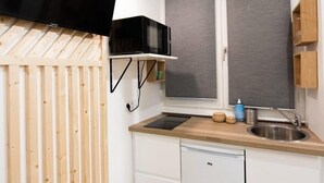Cocina compacta con microondas, pileta y lavavajillas pequeño.