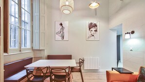 A dining area with a table, chairs, a bench, and artwork on the wall. - Quiet and cozy 3-bedroom flat – Terreaux/Opéra (Lyon)