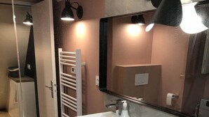 A modern bathroom with two white sinks, a wooden vanity, a towel rack, and a large mirror. - Quiet and cozy 3-bedroom flat – Terreaux/Opéra (Lyon)